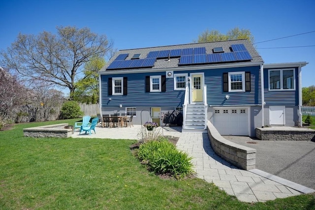 242 Furnace Brook Pkwy, Quincy, MA 02169 - rear view of house featuring a yard, solar panels, an attached garage, and roof with shingles