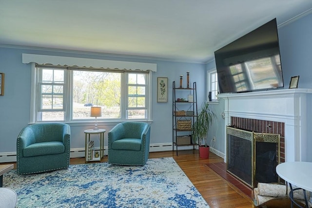 242 Furnace Brook Pkwy, Quincy, MA 02169 - living area featuring ornamental molding, a brick fireplace, wood finished floors, a baseboard heating unit, and baseboards