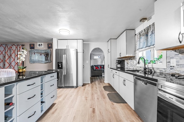 kitchen featuring sink, white cabinets, light wood-type flooring, and appliances with stainless steel finishes