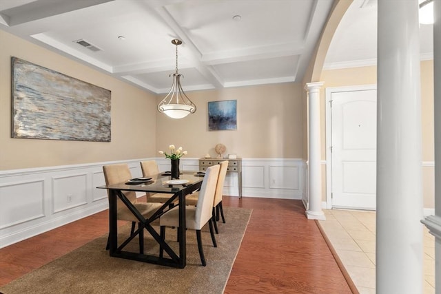 dining room featuring beamed ceiling, wood-type flooring, decorative columns, and coffered ceiling