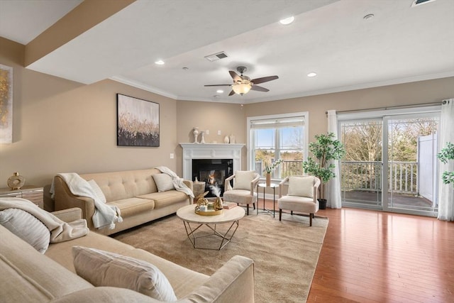 living room featuring crown molding, plenty of natural light, ceiling fan, and light hardwood / wood-style flooring