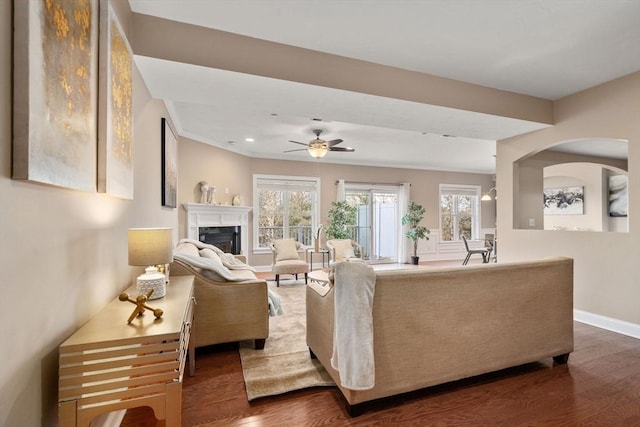 living room featuring ceiling fan and dark wood-type flooring