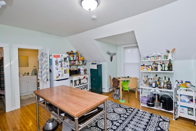 dining area featuring lofted ceiling and light hardwood / wood-style flooring