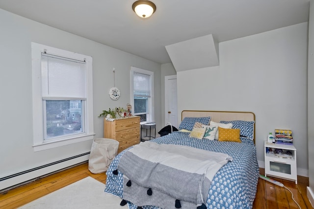 bedroom with wood-type flooring and a baseboard radiator