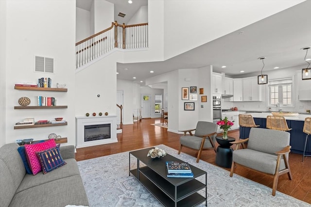 5 Redwood Path Unit 5, Hopkinton, MA 01748 - living area featuring wood finished floors, recessed lighting, a glass covered fireplace, and a towering ceiling