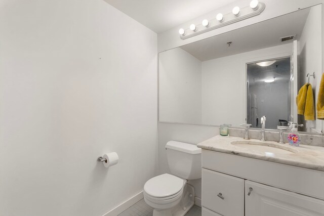 bathroom with vanity, toilet, and tile patterned floors