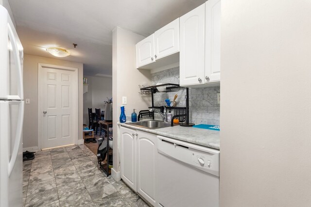 kitchen with white appliances, backsplash, sink, and white cabinets