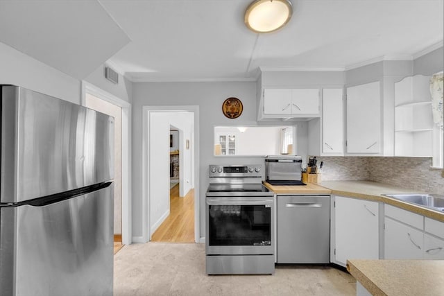 16 Highland Ave, Holden, MA 01520 - kitchen featuring stainless steel appliances, crown molding, white cabinets, a sink, and light countertops