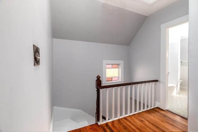 stairs with vaulted ceiling and wood finished floors