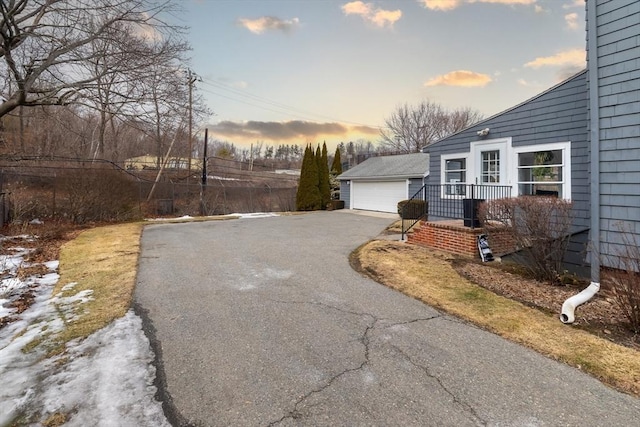 property exterior at dusk with a garage and an outdoor structure