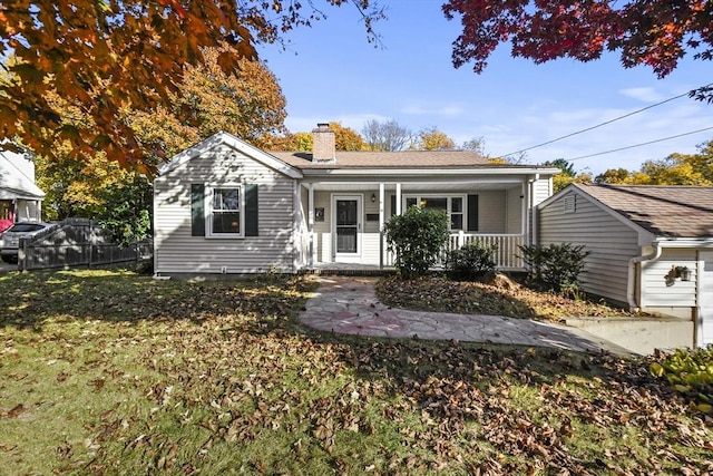ranch-style house featuring covered porch and a chimney
