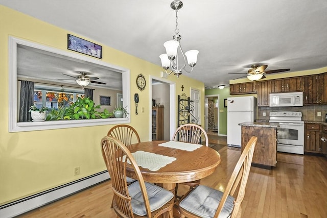 dining space with a baseboard radiator, a ceiling fan, wood finished floors, and a chandelier
