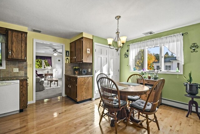 dining room featuring light wood-style flooring, healthy amount of natural light, a chandelier, and a ceiling fan