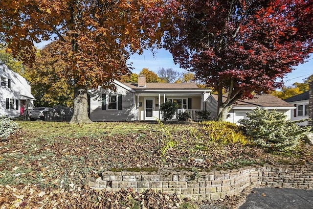 ranch-style house with a chimney and a porch