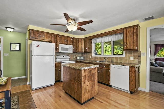 kitchen featuring white appliances, ceiling fan, light wood-style flooring, a sink, and tasteful backsplash