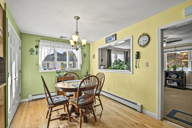dining area with baseboard heating, healthy amount of natural light, and hardwood / wood-style floors