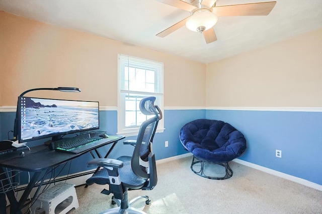 carpeted office space featuring ceiling fan and baseboards