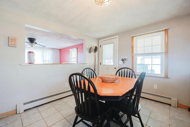 dining room with a baseboard heating unit, light tile patterned floors, and baseboards