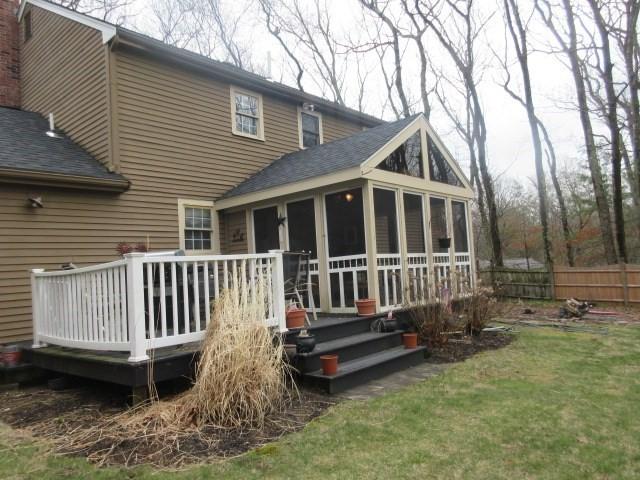 rear view of house with a wooden deck, a sunroom, fence, a yard, and a shingled roof