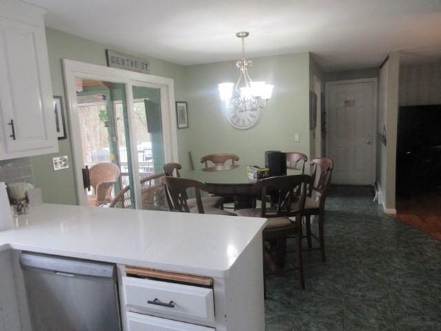 kitchen featuring a peninsula, a chandelier, white cabinets, dishwasher, and decorative light fixtures