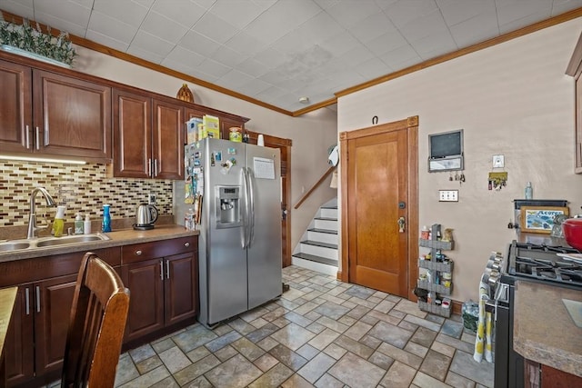 kitchen featuring black gas stove, stainless steel fridge with ice dispenser, a sink, decorative backsplash, and crown molding