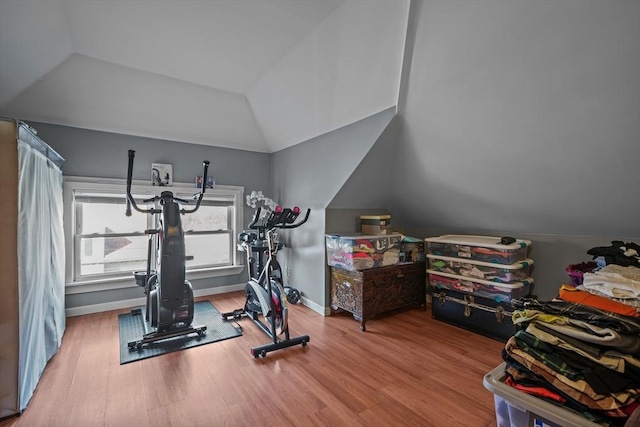 workout area with lofted ceiling, wood finished floors, and baseboards