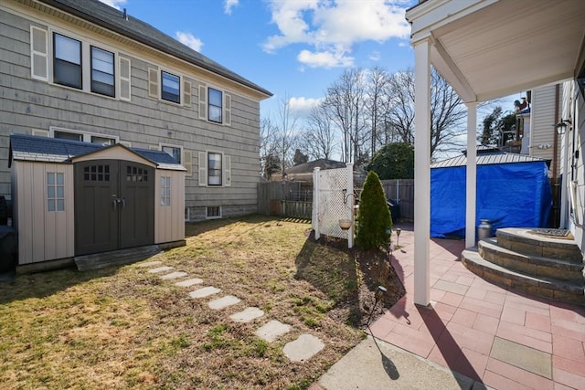 view of yard featuring a storage unit, a patio area, an outdoor structure, and fence