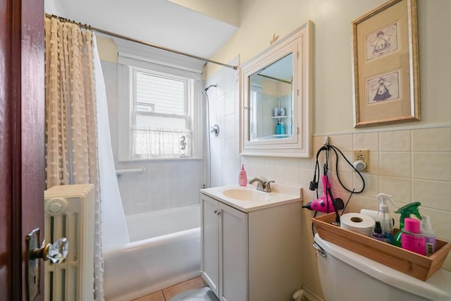 bathroom with vanity, tile walls, toilet, and shower / bath combo with shower curtain