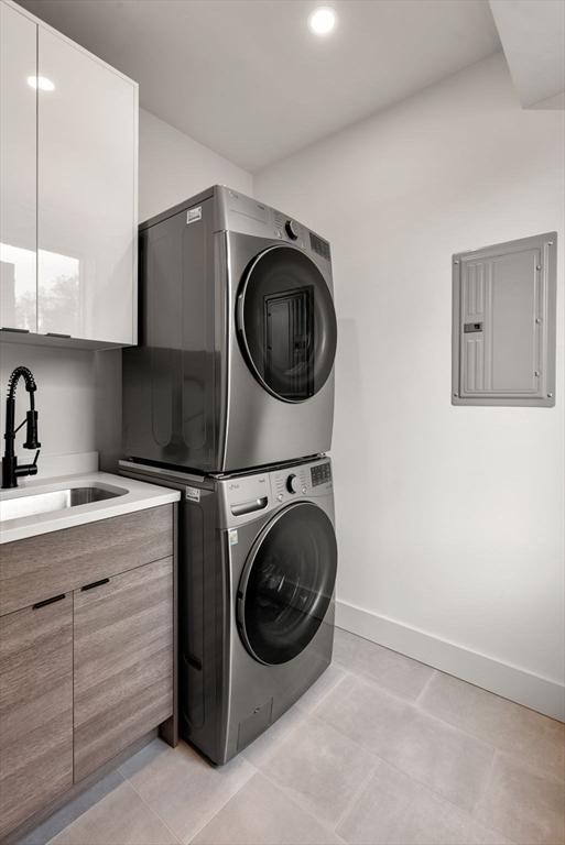 1242 Beacon St, Newton, MA 02468 - washroom featuring stacked washer / dryer, electric panel, baseboards, light tile patterned flooring, and recessed lighting