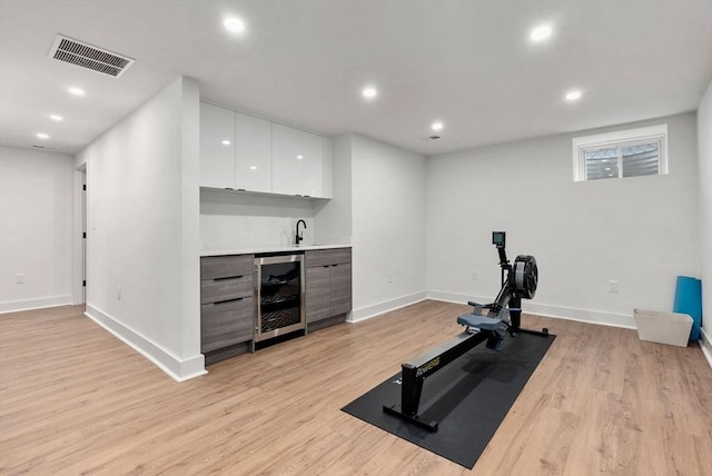 1242 Beacon St, Newton, MA 02468 - workout room featuring wine cooler, wet bar, light wood-style flooring, recessed lighting, and baseboards