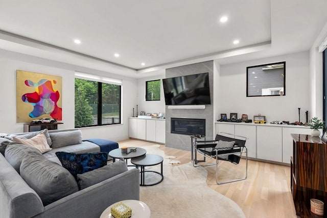 1242 Beacon St, Newton, MA 02468 - living area featuring light wood-type flooring, recessed lighting, a tray ceiling, and a premium fireplace