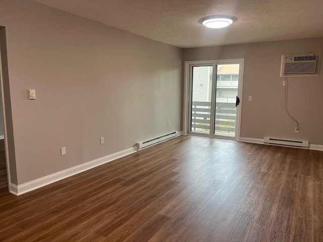 empty room featuring a baseboard heating unit, dark wood-type flooring, a wall mounted AC, and baseboards