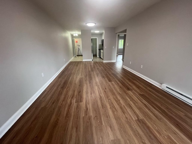 unfurnished room with dark wood-style flooring and baseboards
