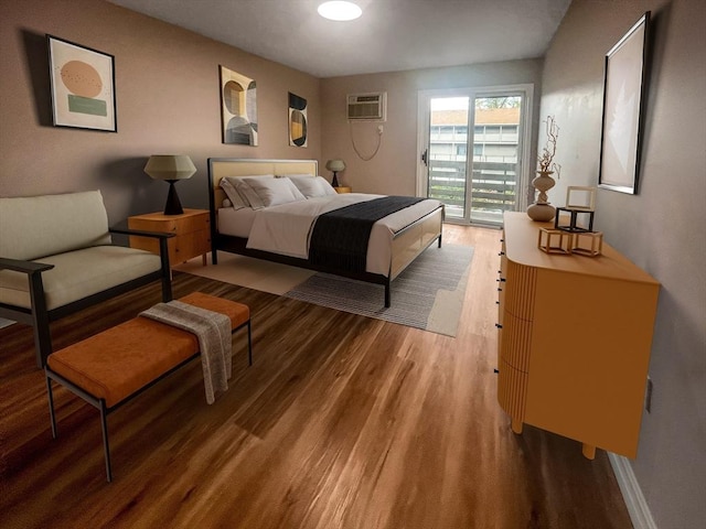 bedroom featuring access to exterior, wood finished floors, an AC wall unit, and baseboards