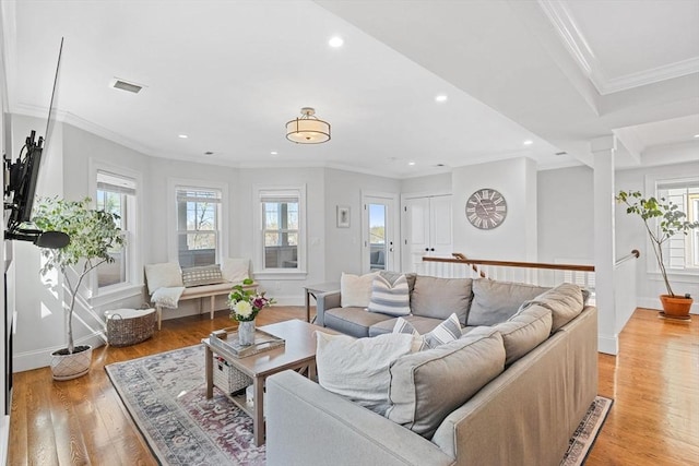 living area with baseboards, ornamental molding, recessed lighting, and light wood-style flooring