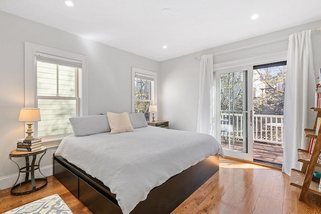 bedroom featuring access to outside, recessed lighting, multiple windows, and wood finished floors