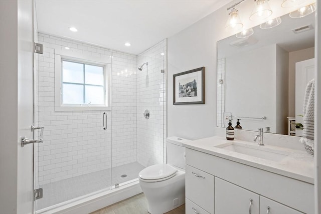 bathroom featuring vanity, a stall shower, toilet, and visible vents
