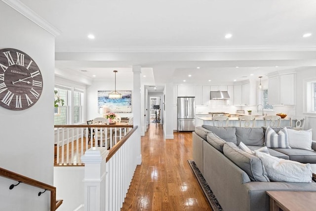 living room with ornamental molding, recessed lighting, and light wood-style flooring