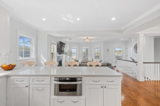 kitchen with light countertops, white cabinets, plenty of natural light, and light wood-style flooring
