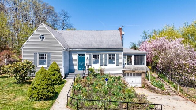 view of front of property featuring a chimney, roof with shingles, fence, concrete driveway, and an attached garage