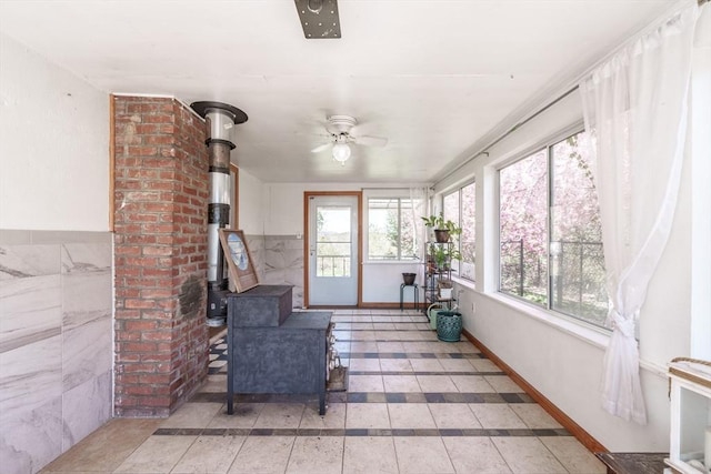 sunroom featuring tile patterned flooring and a wood stove