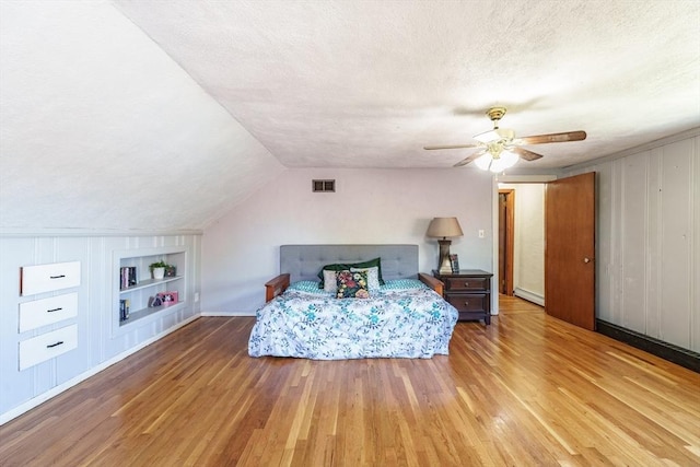 bedroom with visible vents, a ceiling fan, a textured ceiling, and hardwood / wood-style floors