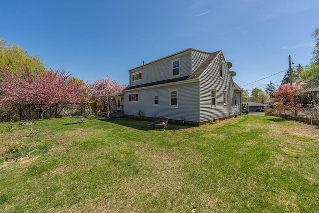 back of house with a lawn and fence