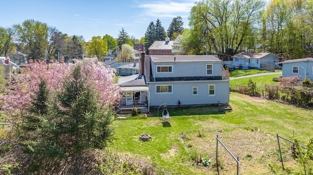rear view of property with fence and a yard