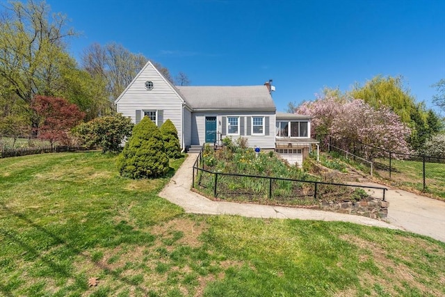 view of front of home featuring a chimney, a front yard, fence, concrete driveway, and an attached garage