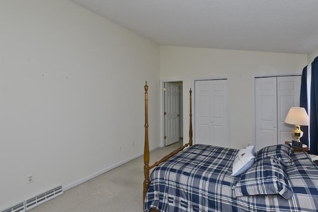 585 Sheridan St Unit 36, Chicopee, MA 01020 - bedroom featuring multiple closets, vaulted ceiling, a baseboard heating unit, baseboards, and light colored carpet