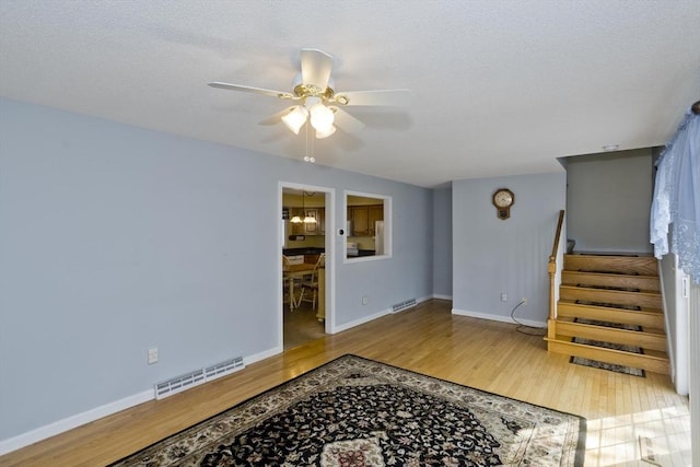 585 Sheridan St Unit 36, Chicopee, MA 01020 - unfurnished living room featuring wood finished floors, visible vents, a ceiling fan, baseboards, and stairs