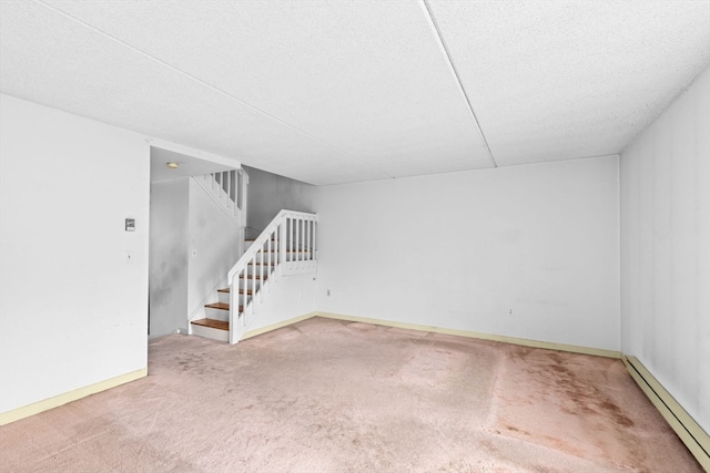 carpeted spare room featuring baseboard heating and a textured ceiling