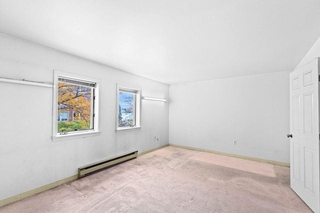 empty room featuring a baseboard radiator, light carpet, and vaulted ceiling