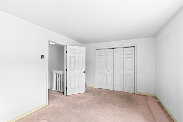 unfurnished bedroom featuring light colored carpet and a closet